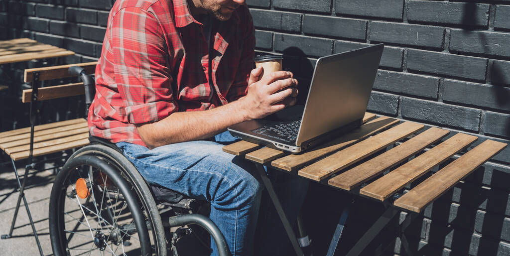 Фрілансер з фізичною вадою в інвалідному візку, що працює на вуличному кафе
 - Фото, зображення