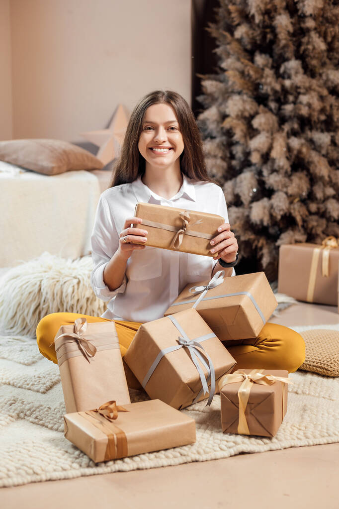 Giovane donna sta avvolgendo regali di Natale per le vacanze - Foto, immagini