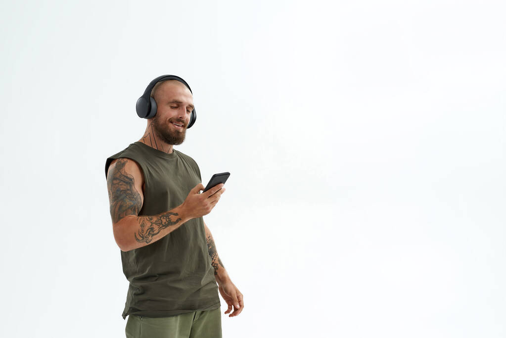 Hombre escuchando música en auriculares en el teléfono móvil - Foto, imagen