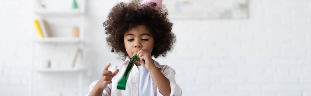frisé afro-américain enfant soufflant dans corne de fête, bannière - Photo, image