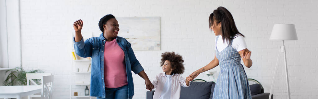 ενθουσιασμένοι αφροαμερικανό παιδί που χορεύει στο σαλόνι με τη μαμά και τη γιαγιά, πανό - Φωτογραφία, εικόνα