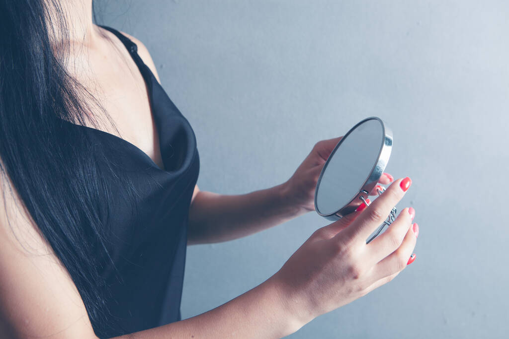jeune femme vérifier maquillage avec un miroir - Photo, image