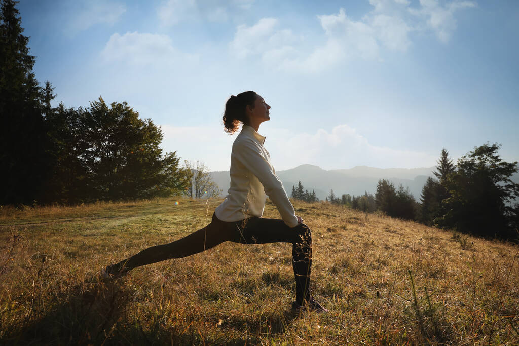 Donna che pratica yoga in montagna all'alba - Foto, immagini