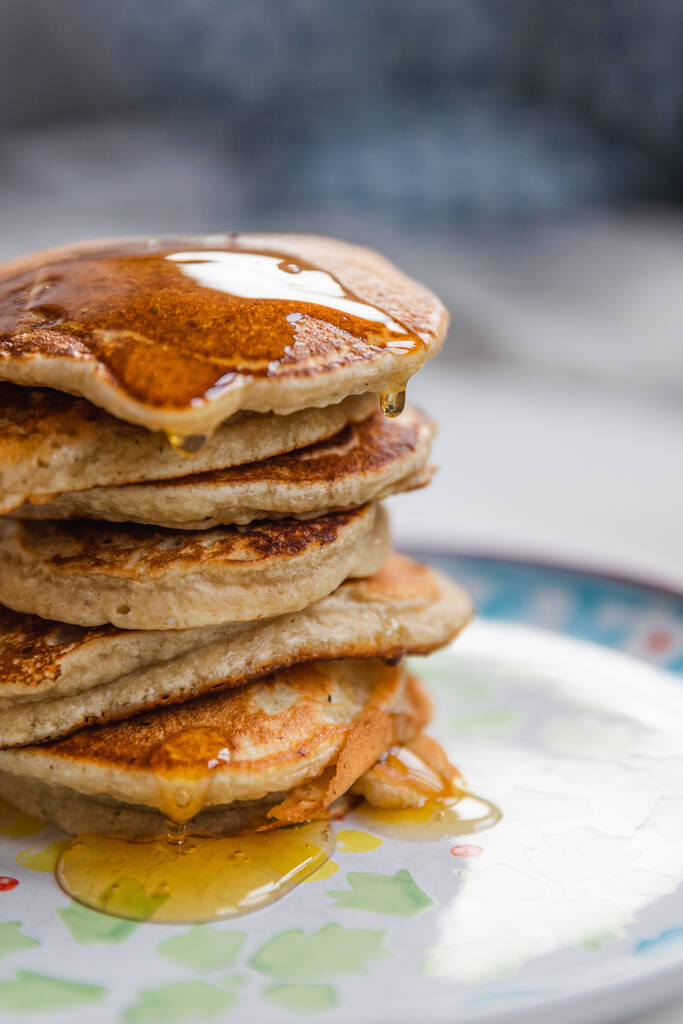A closeup of a stack of pancakes with dripping maple syrup - Fotografie, Obrázek