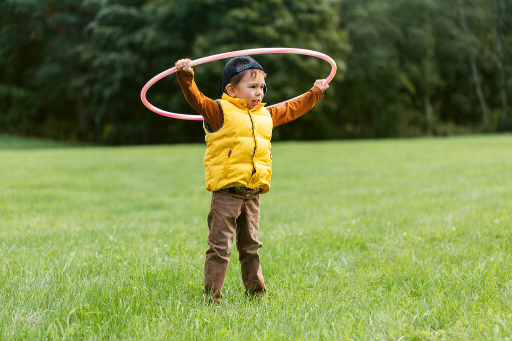 felice bambino che gioca con hula hoop al parco - Foto, immagini