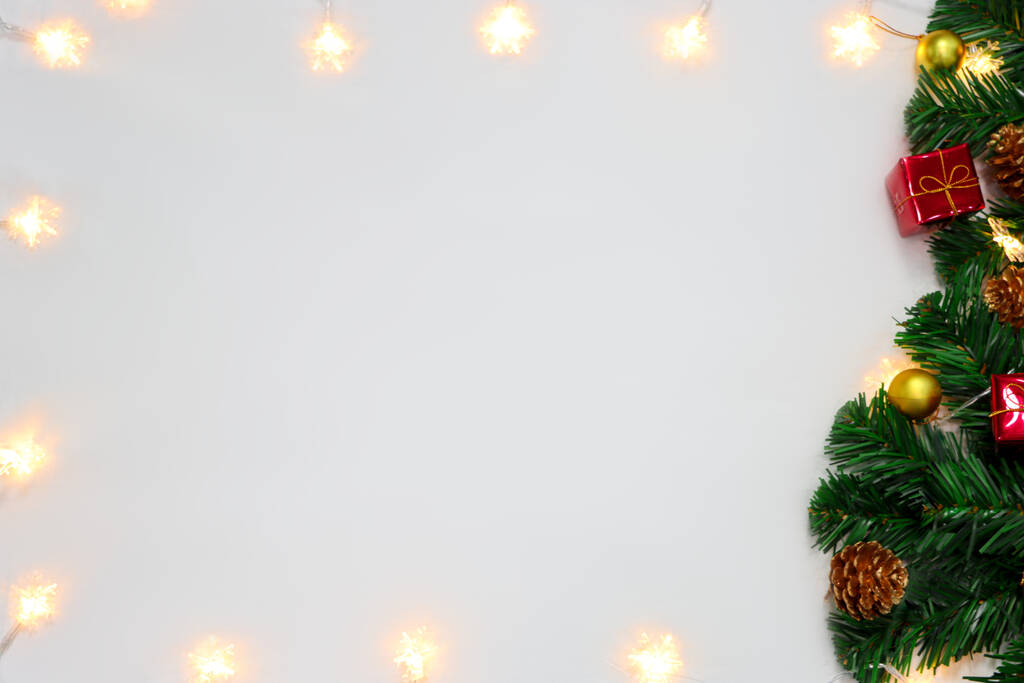 Vánoční ozdoba. Rámeček vánoční světlo, větev vánoční stromeček, a vánoční ozdoby na bílém pozadí s prostorem pro text. Pohled shora, byt ležel - Fotografie, Obrázek