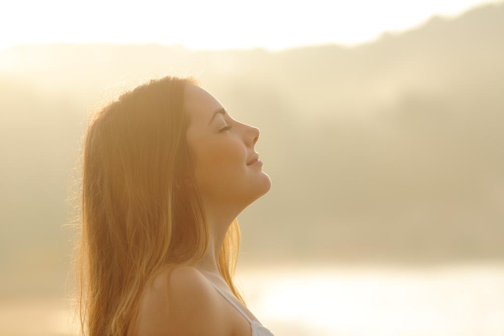 Женщина дышит глубоким свежим воздухом на рассвете
 - Фото, изображение