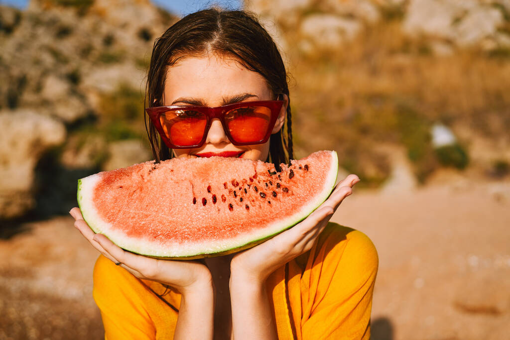 Frau am Strand in der Nähe des Ozeans isst Wassermelone - Foto, Bild