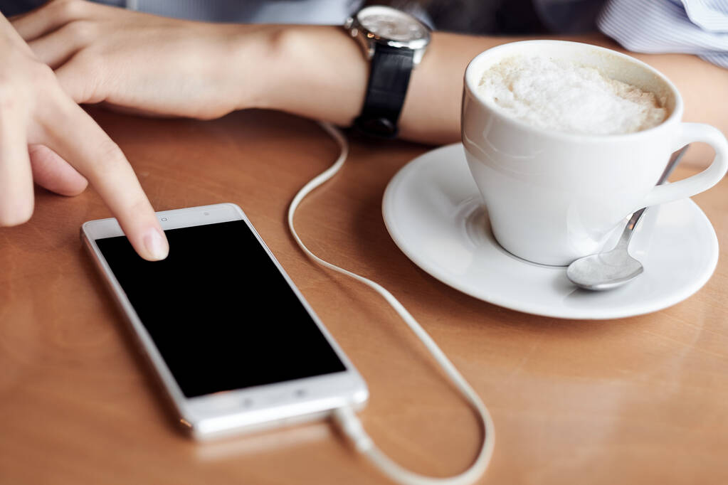 Mãos de mulher com telefone inteligente, fones de ouvido e xícara de chá. Para montagem de exibição gráfica - Foto, Imagem