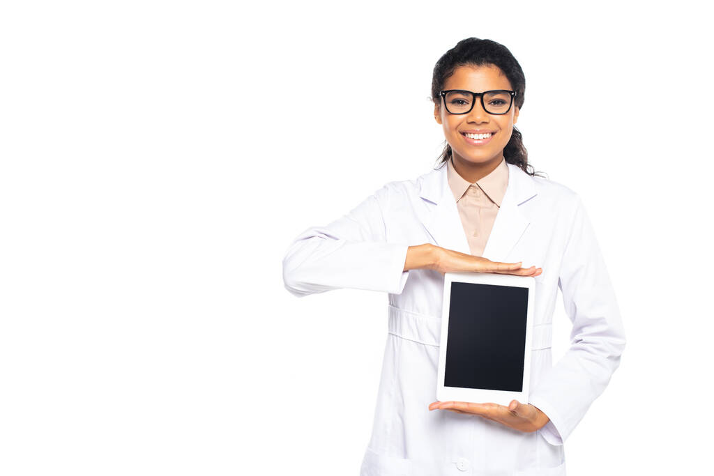 Lächelnder afrikanischer Augenarzt in Brille mit digitalem Tablet und leerem Bildschirm auf weißem Hintergrund  - Foto, Bild