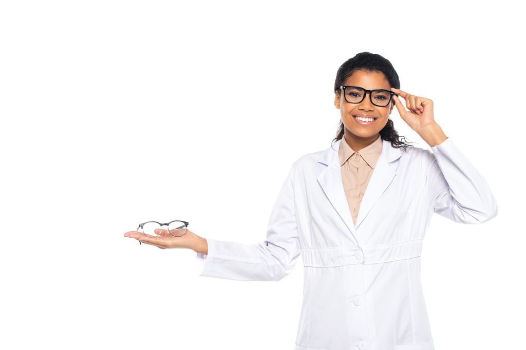 Αφροαμερικάνος οφθαλμίατρος ρυθμίζοντας γυαλιά που απομονώνονται σε λευκό  - Φωτογραφία, εικόνα