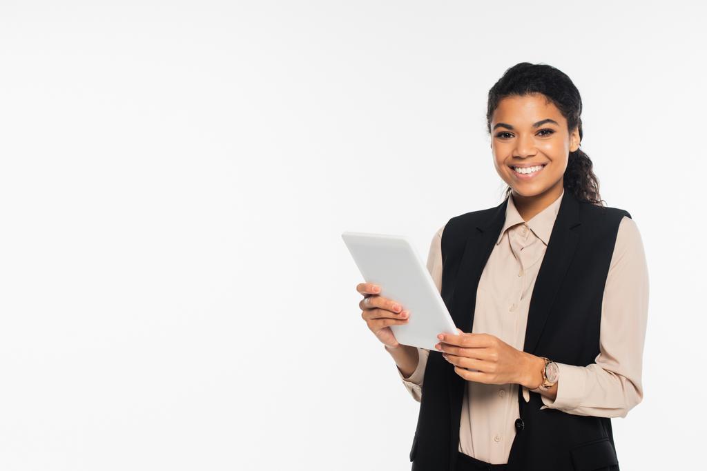 Sorridente donna d'affari afroamericana in gilet con tablet digitale isolato su bianco  - Foto, immagini