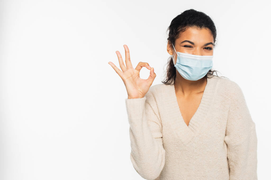 African american woman in medical mask winking and showing ok sign isolated on white - Photo, Image