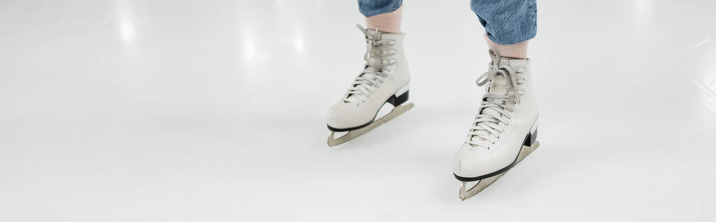 vista recortada de la mujer en patines de hielo patinaje sobre pista de patinaje, bandera - Foto, imagen