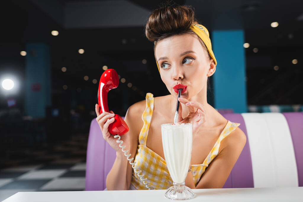 молода піна жінка п'є молочний коктейль і тримає червоний килимок
  - Фото, зображення