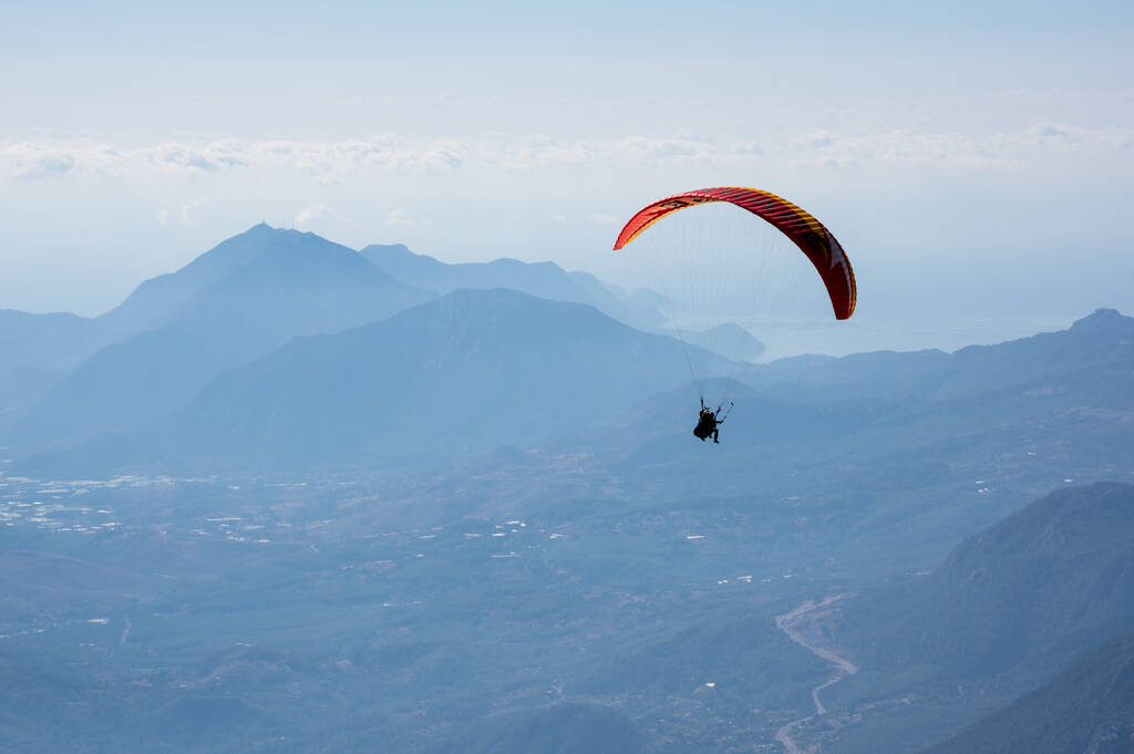 Paraglider vliegen over bergen bij Kemer, een badplaats aan de Turkse Rivièra in de provincie Antalya, Turkije - Foto, afbeelding