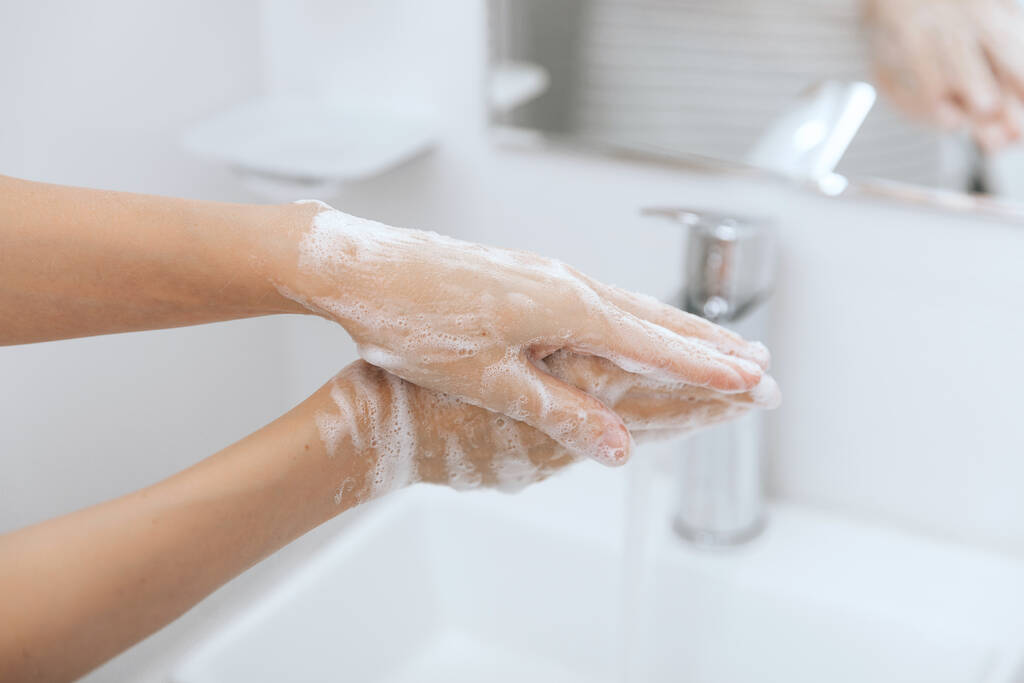 Hände waschen unter dem fließenden Wasserhahn. Hygienekonzept Hand Detail. Händewaschen mit Seife zur Vorbeugung des Coronavirus, Hygiene gegen die Ausbreitung des Coronavirus im oder im öffentlichen Waschraum - Foto, Bild