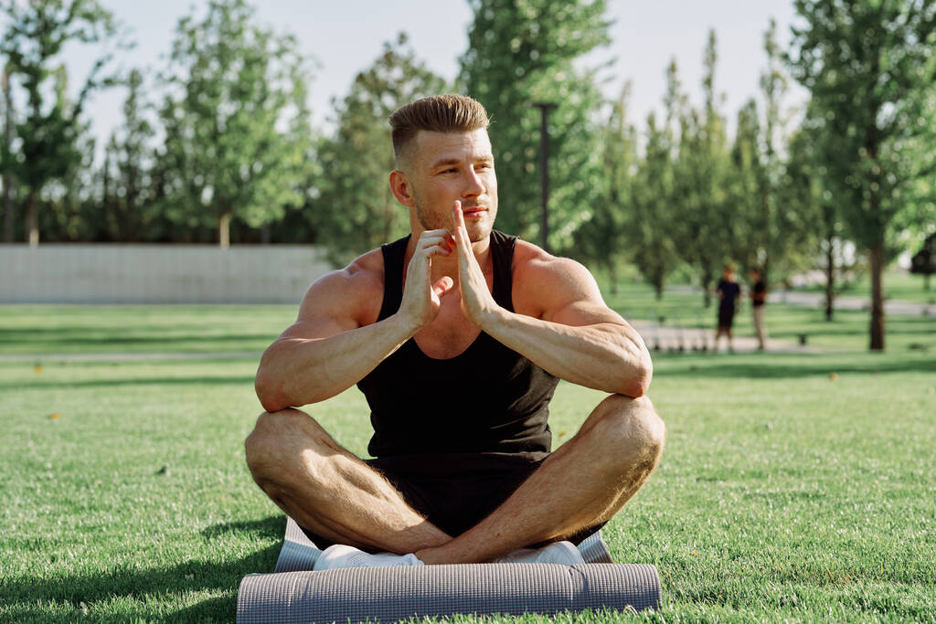 desportivo homem sentado no gramado no parque de treinamento - Foto, Imagem