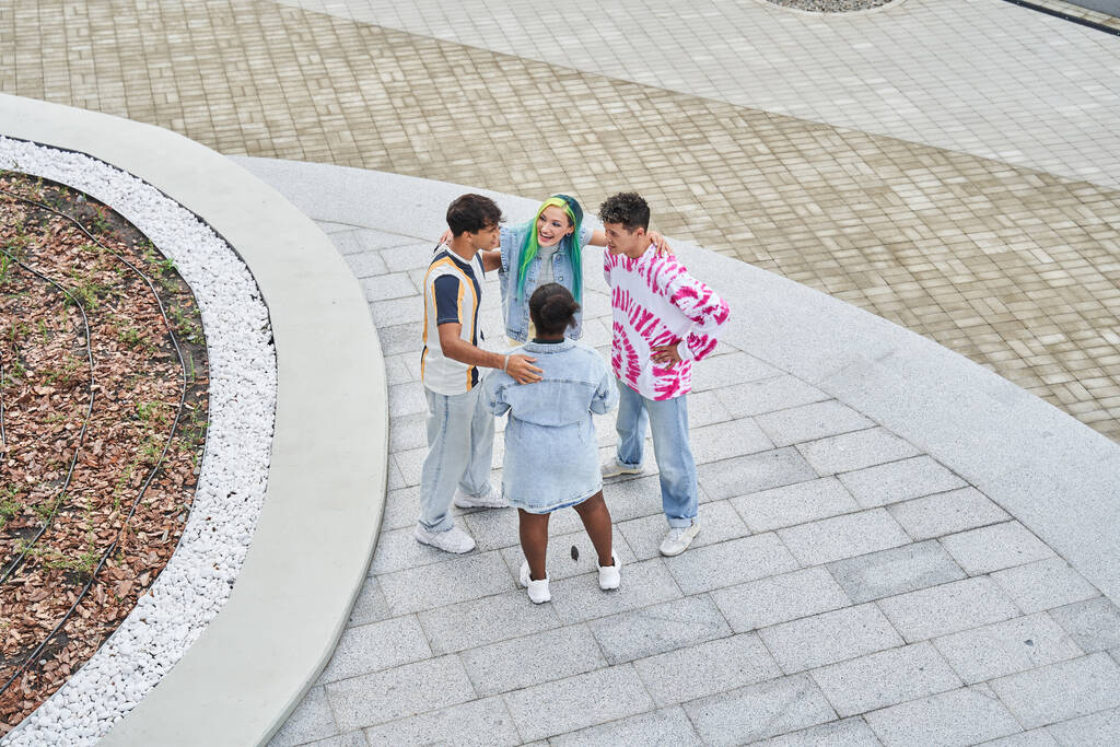 Různorodé stylové studenty objímající a smějící se při chůzi na ulici - Fotografie, Obrázek
