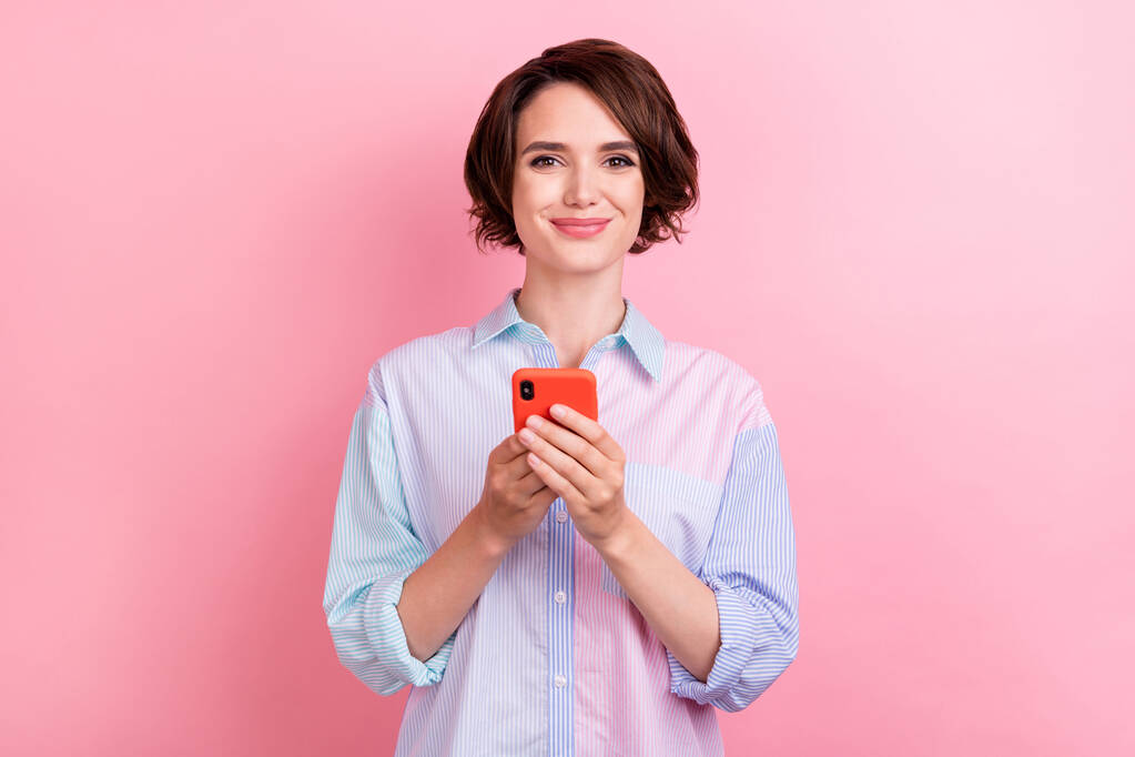 Фото молодої жінки щасливої позитивної посмішки перегляд смартфона в балачках смс ізольовано на фоні рожевого кольору
 - Фото, зображення