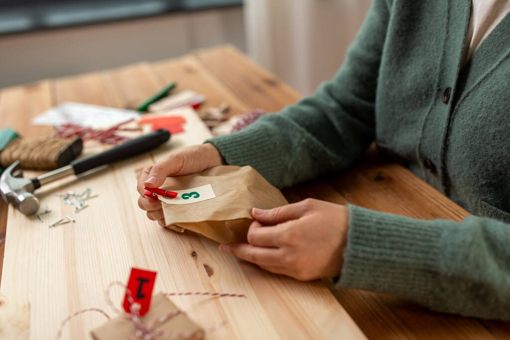 manos haciendo calendario de adviento de Navidad en casa - Foto, Imagen