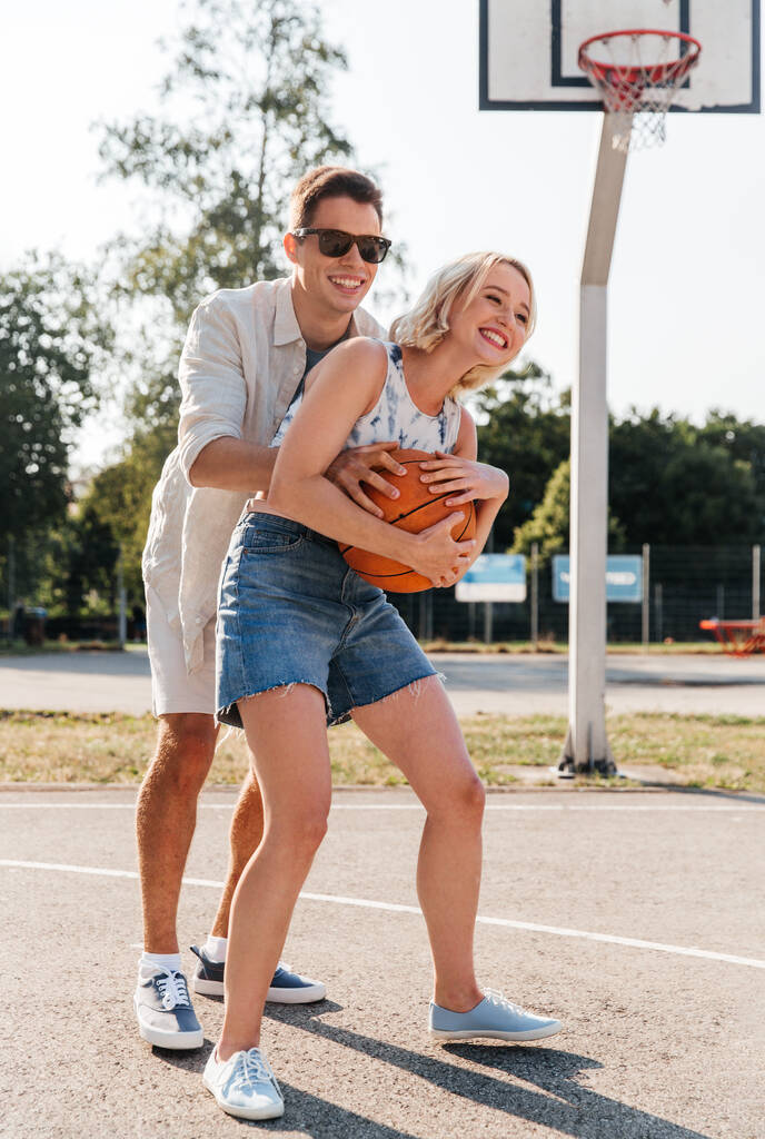 Mutlu çift oyun bahçesinde basketbol oynuyor. - Fotoğraf, Görsel