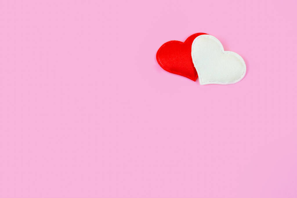 上隅に2つの心を持つ最小限のピンクの背景。バレンタインデーをテーマにしたテンプレート、カードのためのロマンチックなレターヘッド、招待状、コピースペース - 写真・画像