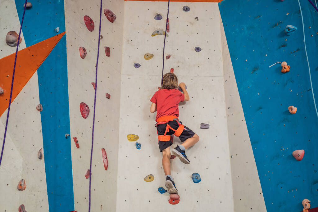 Boy at the climbing wall without a helmet, danger at the climbing wall - Photo, Image