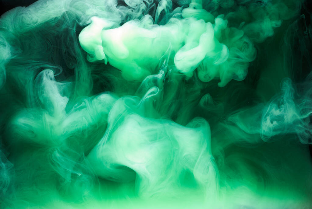 Πράσινος καπνός σε μαύρο φόντο μελάνι, πολύχρωμη ομίχλη, αφηρημένη στροβιλίζονται σμαραγδένια θάλασσα του ωκεανού, ακρυλικό χρώμα υποθαλάσσια χρωστική - Φωτογραφία, εικόνα