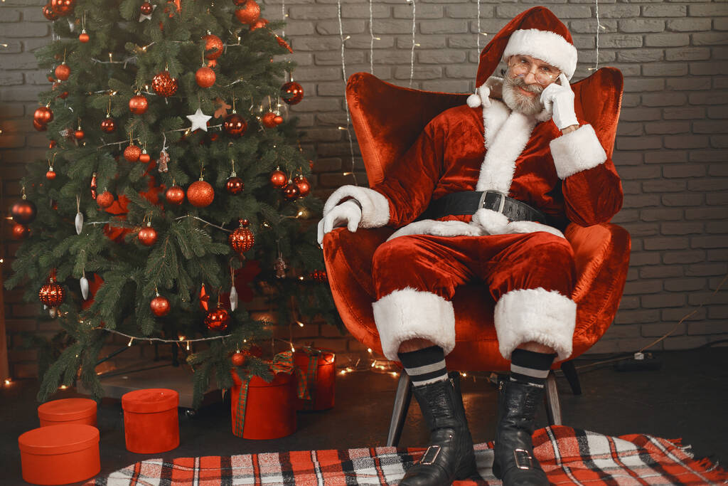 Muž v kostýmu Santa Clause sedící na židli - Fotografie, Obrázek