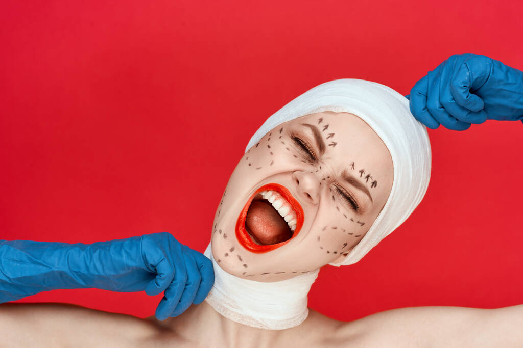 a person in blue gloves syringe in hands contour on the face lifting red background - Photo, Image