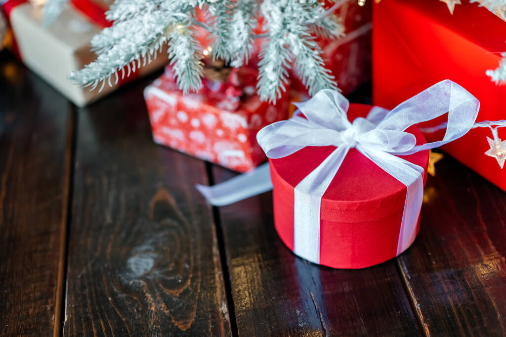 Cajas de regalo de Navidad bajo el árbol, en el suelo de madera. - Foto, Imagen