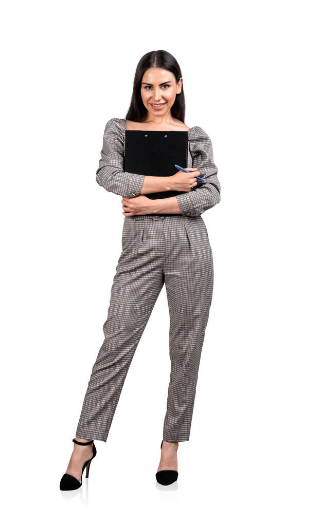 Joven mujer de negocios atractiva con mono formal está sosteniendo portapapeles. Concepto de personas de negocios exitosas contemporáneas. Aislado sobre fondo blanco - Foto, imagen