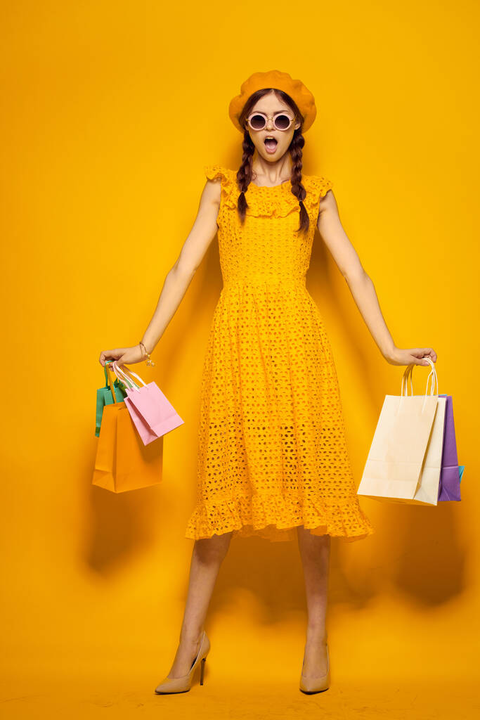 csinos nő vásárlás szórakozás életmód sárga háttér - Fotó, kép
