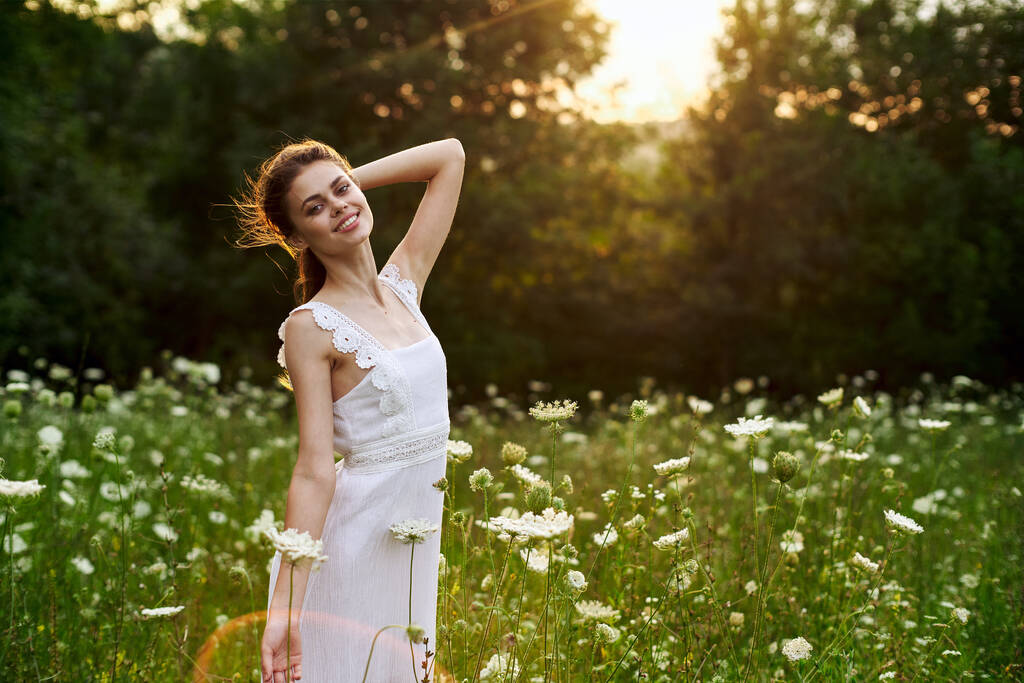 Женщина в белом платье в поле цветы солнце свобода природы - Фото, изображение