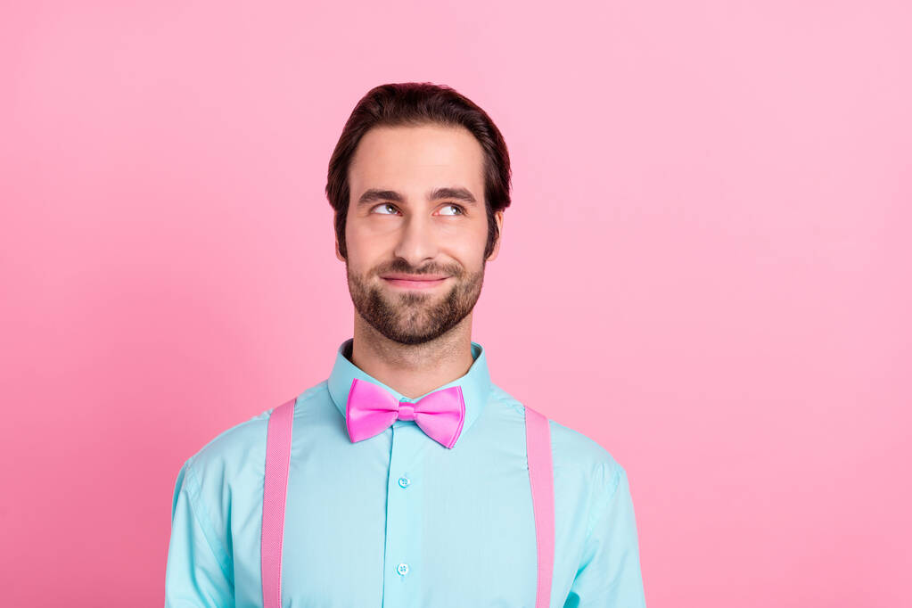 Photo de rêve mignon jeune homme porter tenue turquoise souriant regardant vide espace isolé couleur rose fond - Photo, image