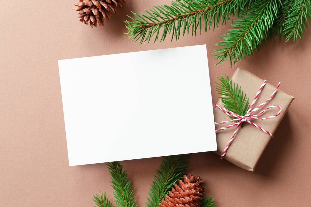 Tarjeta de felicitación de Navidad o Año Nuevo maqueta con caja de regalo y ramas de abeto con conos - Foto, Imagen