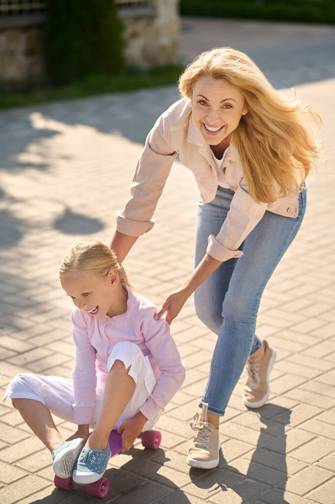 Mãe apoiar uma menina enquanto ela skate - Foto, Imagem