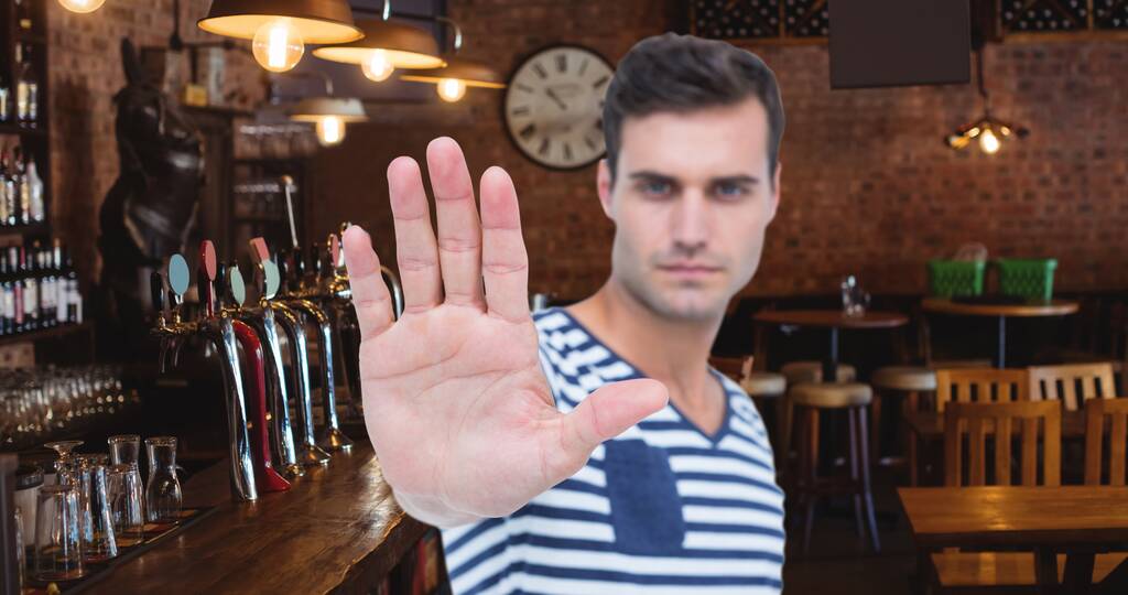 Портрет молодої людини, що показує стоп- жест рукою в барі. цифровий склад способу життя та алкоголізму
. - Фото, зображення