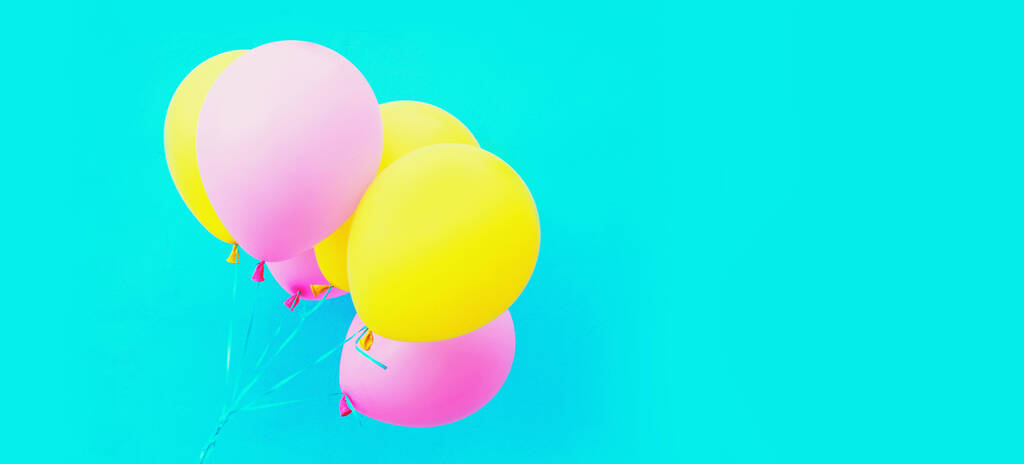 Bande de ballons roses jaunes colorés et festifs sur fond bleu - Photo, image