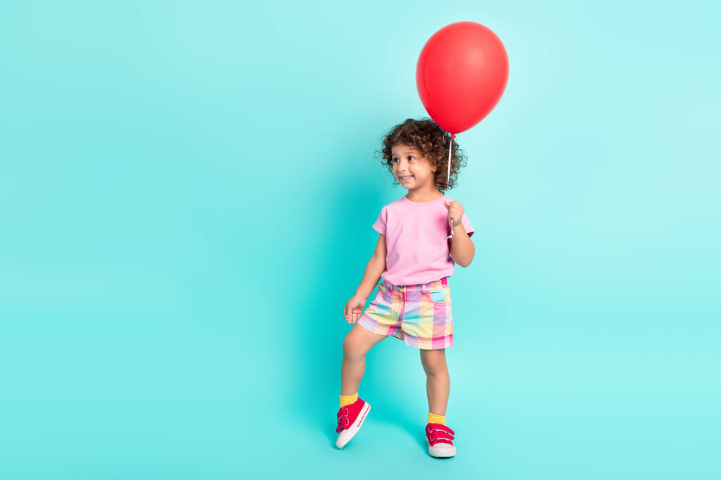 Фотографія молодої маленької іспаномовної дівчинки щаслива позитивна посмішка тримайте повітряні кулі ізольовані на бірюзовому кольоровому фоні
 - Фото, зображення