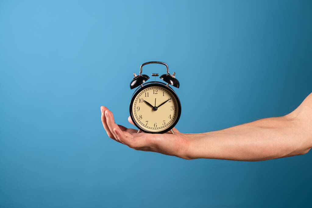 Hurry up, its time to act, concept. A mans hand holds a vintage alarm clock, - Photo, Image
