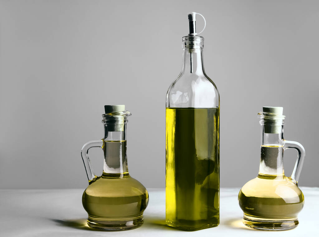 Set of vegetable or olive oil glass bottles  on isolated  background. The collection of three narrow and high bottles. - Photo, Image