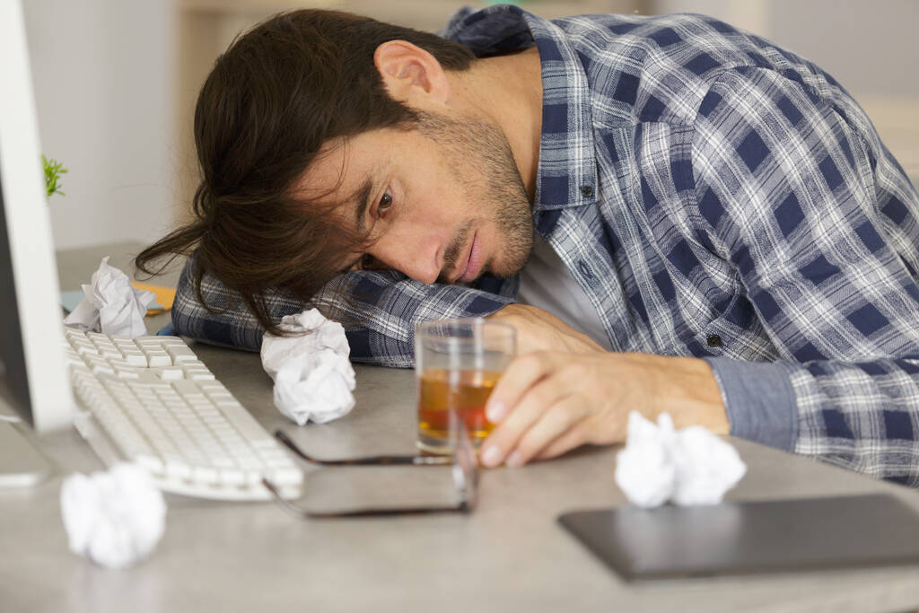 Geschäftsmann trinkt vor Stress am Arbeitsplatz - Foto, Bild