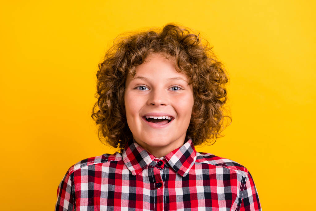 Foto de lindo peinado de jengibre niño risa usar camisa a cuadros rojo aislado sobre fondo de color amarillo - Foto, imagen