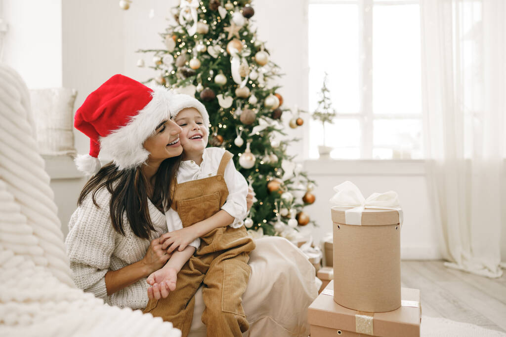Mutlu anne ve oğlunun portresi Noel 'i şenlikli bir odada kutluyor. - Fotoğraf, Görsel