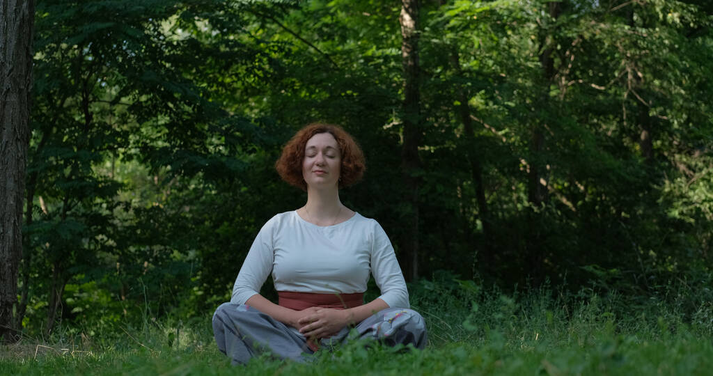 夏公園や森の中で気功や瞑想を練習女性 - 写真・画像