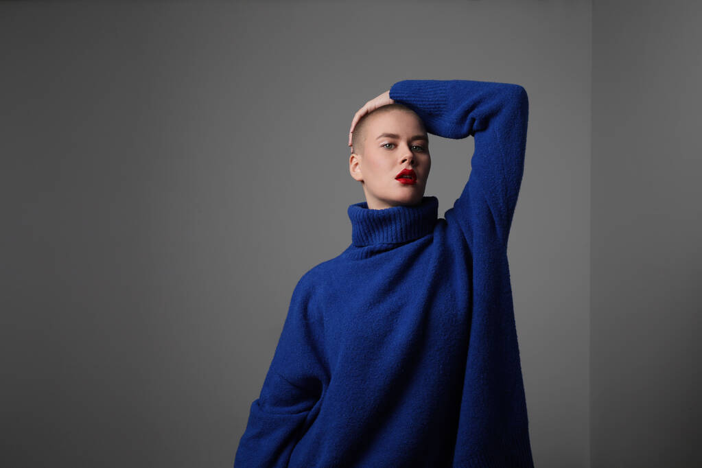 Close-up of beautiful bald young woman, wearing blue sweater. Isolated. - Photo, Image