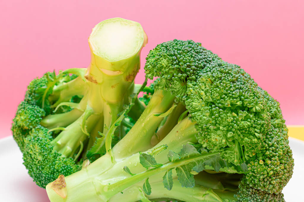 Fresh and Raw Broccoli Against the Pink Background Неприготоване зелене капуста - Фото, зображення