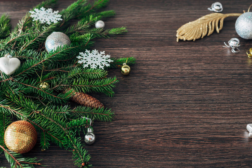 Kerstboom takken en sneeuwvlokken op een bruine achtergrond met kopieerruimte - Foto, afbeelding